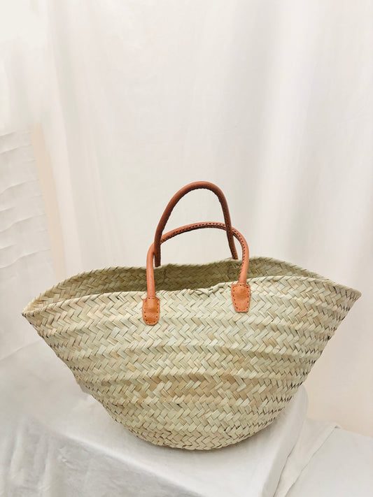 Handwoven palm leaf basket with leather handles